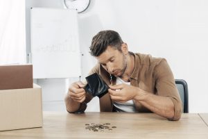 Worried small business owner checking empty wallet due to unexpected importing costs