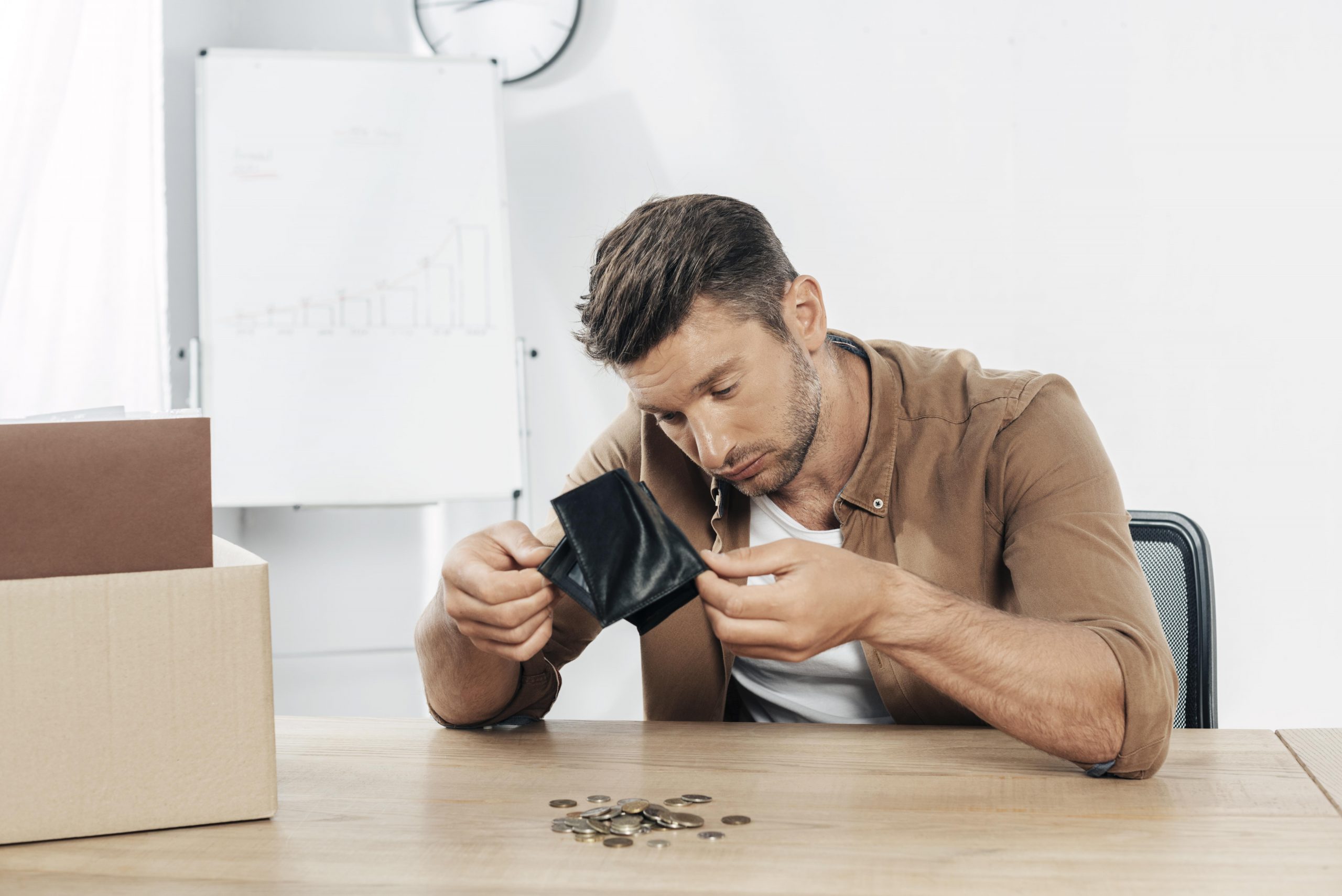 Worried small business owner checking empty wallet due to unexpected importing costs