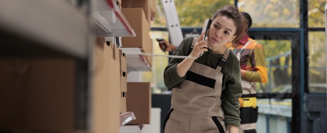 Warehouse worker on the phone, managing product inventory and shipping logistics